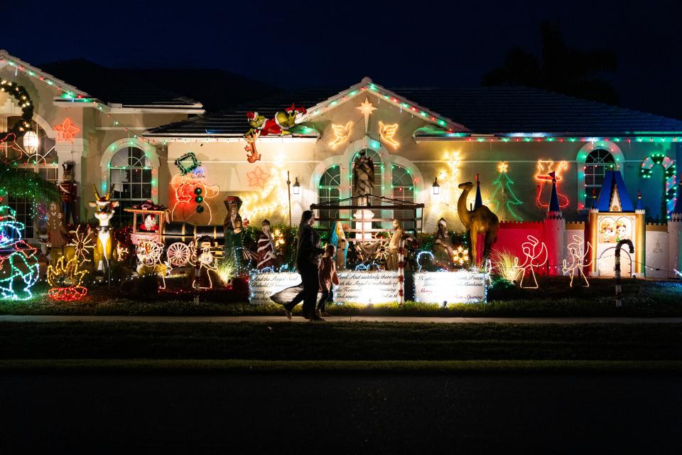 People walk on the sidewalk outside of the home of Ron Spering in Marco Island on Wednesday, Dec. 6, 2023.