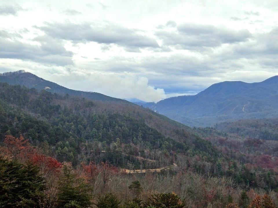 Smoke from a 1,193-acre wildfire can be seen in the distance. The fire erupted from a traffic accident on I-40 near the border of North Carolina and Tennessee, according to the U.S. Forest Service.