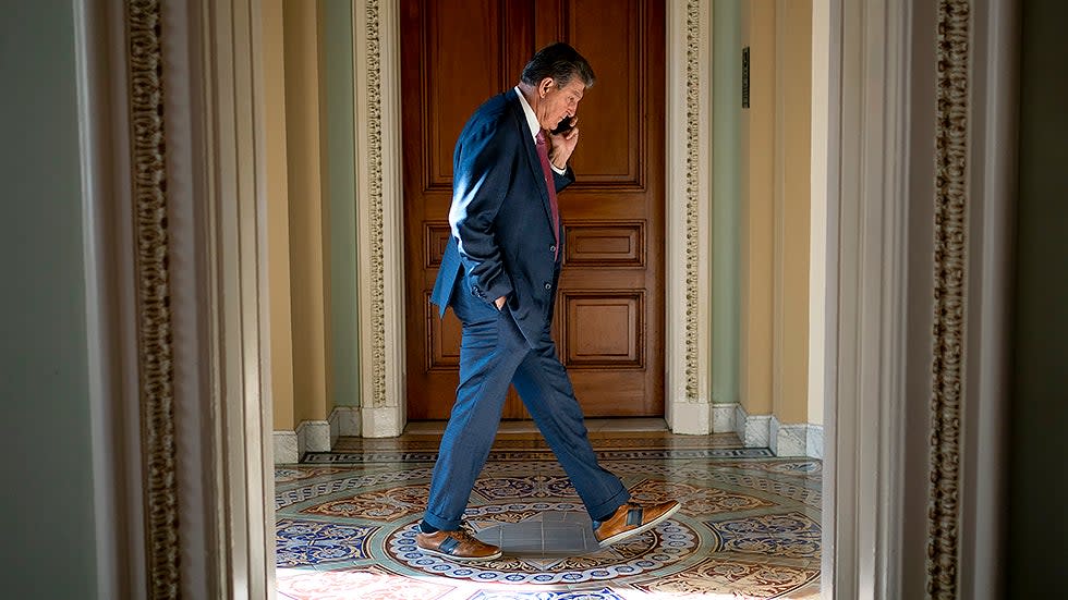 Sen. Joe Manchin (D-W.Va.) is seen on the phone prior to the weekly Senate Democratic policy luncheon on Tuesday, December 7, 2021. 