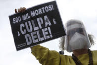 A demonstrator holds a sign with a message that reads in Portuguese; "500K deaths! His fault!" during a demonstration against Brazilian President Jair Bolsonaro's handling of the coronavirus pandemic and economic policies protesters say harm the interests of the poor and working class, in Rio de Janeiro, Brazil, Saturday, June 19, 2021. Brazil is approaching an official COVID-19 death toll of 500,000 — second-highest in the world. (AP Photo/Bruna Prado)