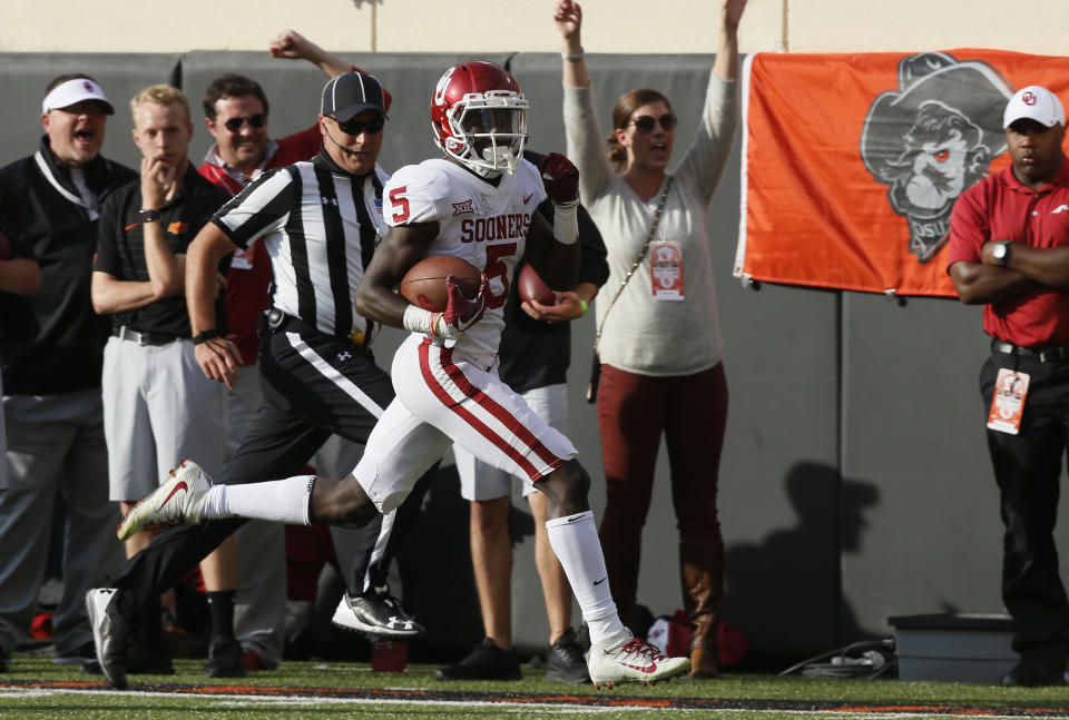 FILE - Oklahoma wide receiver Marquise Brown (5) takes off downfield for a touchdown in the first half of an NCAA college football game in Stillwater, Okla., Nov. 4, 2017. Oklahoma and Oklahoma State will meet on Saturday for the final time before Oklahoma leaves the Big 12 for the Southeastern Conference. (AP Photo/Sue Ogrocki, File)