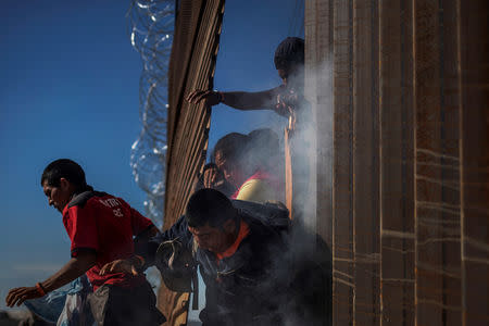 FILE PHOTO: Migrants, part of a caravan of thousands from Central America trying to reach the United States, return to Mexico after being hit by tear gas by U.S. Customs and Border Protection officials after attempting to illegally cross the border wall into the United States in Tijuana, Mexico November 25, 2018. REUTERS/Adrees Latif/File Photo