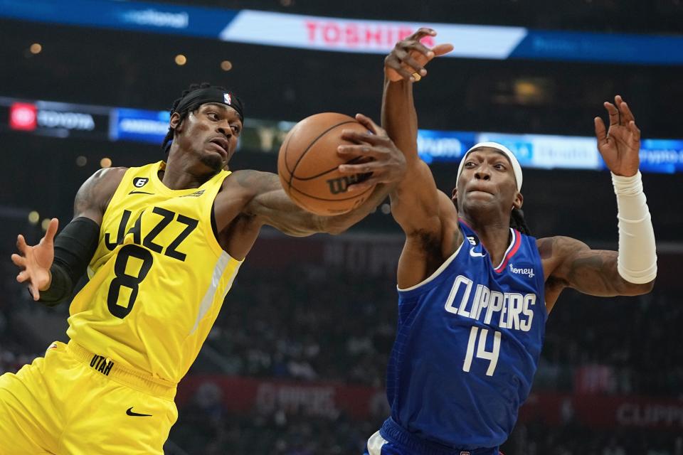 Utah Jazz forward Jarred Vanderbilt, left, grabs a rebound away from Los Angeles Clippers guard Terance Mann during the first half of an NBA basketball game Monday, Nov. 21, 2022, in Los Angeles. (AP Photo/Mark J. Terrill)