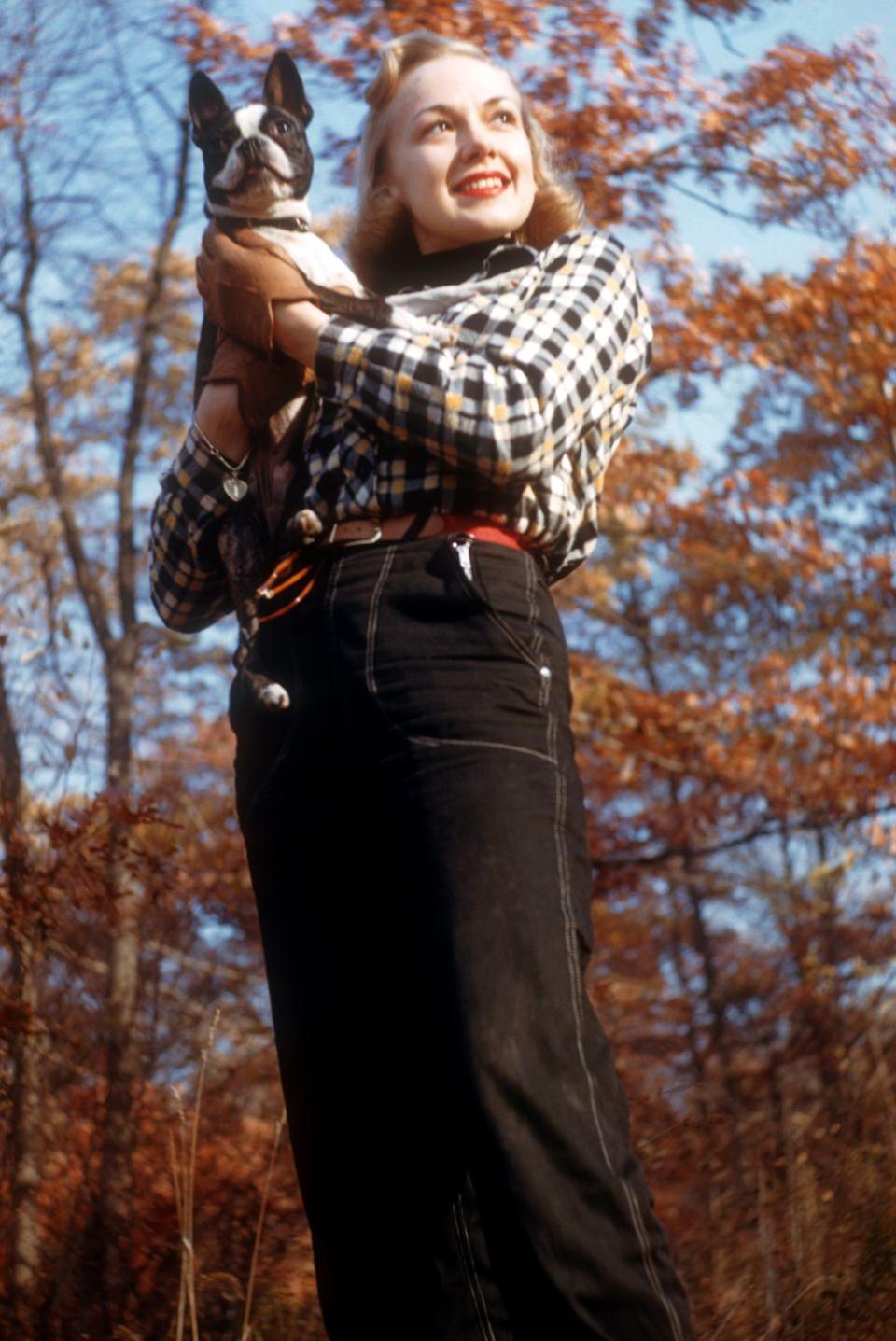 <p>Actress and singer Edie Adams opted for high-waisted, black denim with a checkered top during her October 1952 photo shoot alongside her pet Boston Terrier.<br></p>