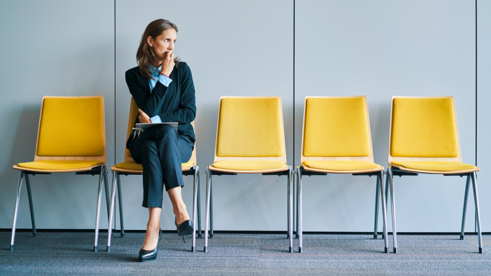 A woman in a waiting room looking nervous for a job interview.