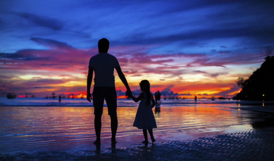 Father and daughter silhouettes in sunset at beach on Boracay