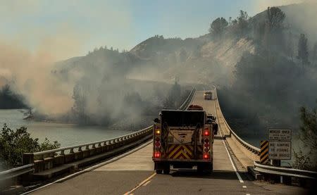 A firetruck drives across the Merced River at the Bagby bridge after authorities ordered evacuations due to the Detwiler fire in Mariposa, California, U.S. July 18, 2017. REUTERS/Al Golub