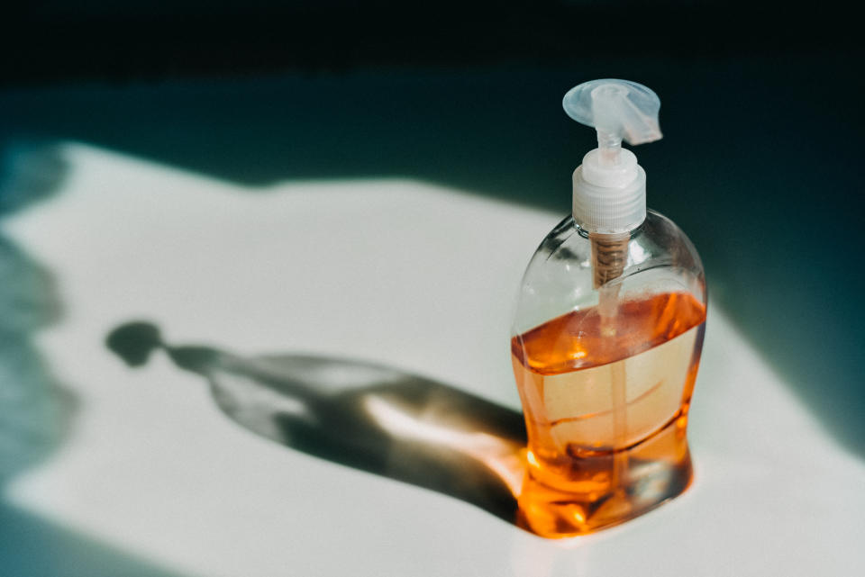Bottle of liquid soap casting a shadow on a surface