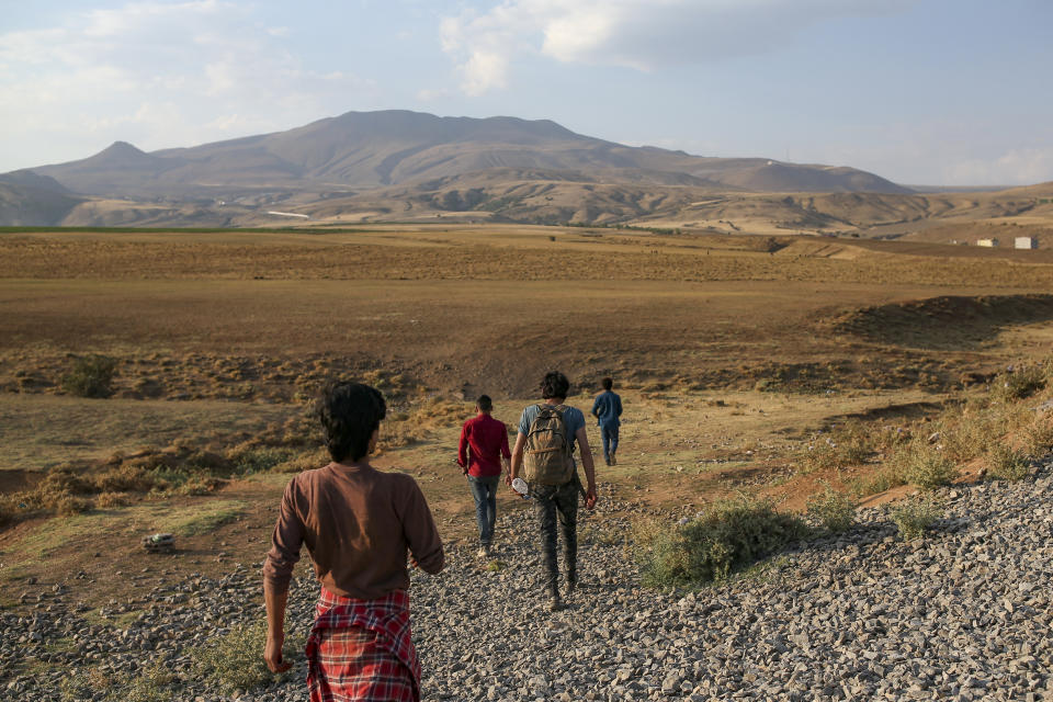 Young men who say they deserted the Afghan military and fled to Turkey through Iran walk in the countryside in Tatvan, in Bitlis Province in eastern Turkey, Tuesday, Aug. 17, 2021. Turkey is concerned about increased migration across the Turkish-Iranian border as Afghans flee the Taliban advance in their country.(AP Photo/Emrah Gurel)