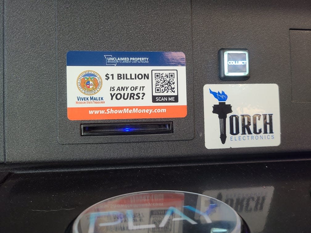 A sticker promoting the state’s Unclaimed Property Program on a machine owned by Torch Electronics.