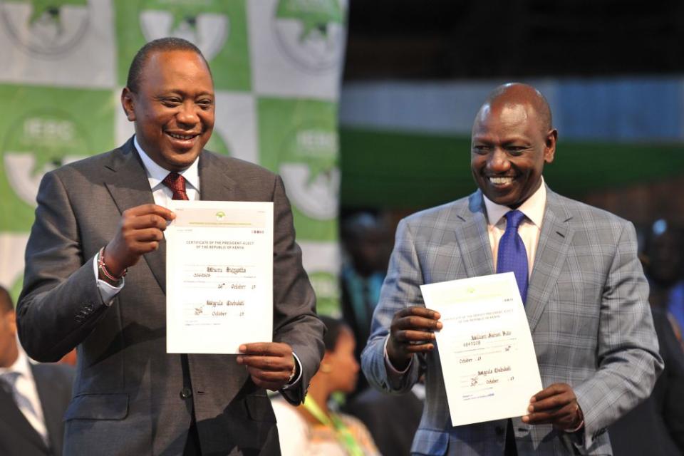 Kenya's president-elect, Uhuru Kenyatta (L) with his running mate William Ruto hold up certificates of election on Oct. 30, 2017 at the national tallying center at Bomas of Kenya, where they were announced winners of a repeat presidential poll by the Independent Electoral and Boundaries Commission chairman. Kenyatta was declared victor of the country's deeply divisive elections on Oct. 30, taking 98 percent of the ballots cast in a poll boycotted by his rival Raila Odinga.<span class="copyright">Tony Karumba—AFP via Getty Images</span>