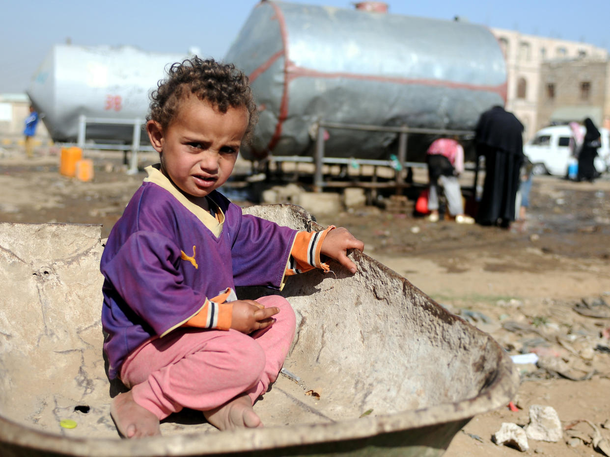 A Yemeni child sits on a wheelbarrow as he waits for his mother to fill their jerry cans with clean water: Getty Images