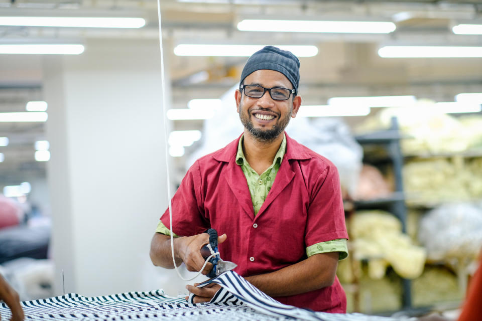 A garment worker dons his new glasses in a VF Corporation supplier factory in Bangladesh.