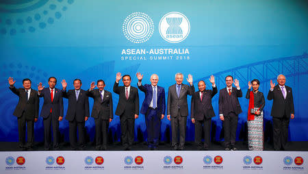 Laos' Prime Minister Thongloun Sisoulith, Indonesia's President Joko Widodo, Cambodia's Prime Minister Hun Sen, Brunei's Sultan and Prime Minister Sultan Bokliah, Thailand's Prime Minister Prayut Chan-O-Cha, Australia's Prime Minister Malcolm Turnbull, Singapore's Prime Minister Lee Hsien Loong, Vietnam's Prime Minister Nguyen Xuan Phuc, Philippines' Secretary of Foreign Affairs Alan Peter Cayetano, Myanmar's State Counsellor Aung San Suu Kyi and Malaysia's Prime Minister Najib Razak wave as they stand together during the Leaders Welcome and Family Photo at the one-off summit of 10-member Association of Southeast Asian Nations (ASEAN) in Sydney, Australia, March 17, 2018. REUTERS/David Gray