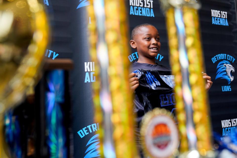 Jashon Howell, 8, holds up his Detroit City Lions jersey after signing to join they 8U team at the Culture Academy celebrated Culture Empowerment Day event in Detroit at Little Caesars Arena on Sunday, June 25, 2023. The event featured live panels, live music, workshops and games. 