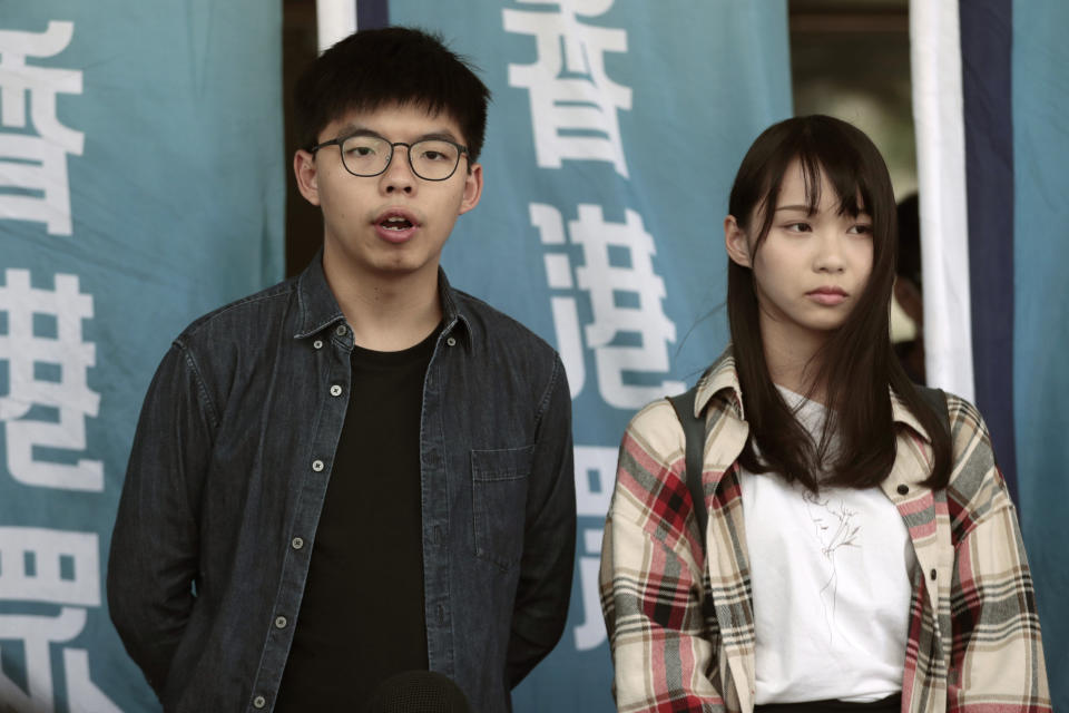 Pro-democracy activists Joshua Wong, left, and Agnes Chow speak to media outside a district court upon arrival for a hearing in Hong Kong, Friday, Nov. 8, 2019. Wong and Chow were charged with inciting people to join a protest in June and are currently on bail. (AP Photo/Dita Alangkara)