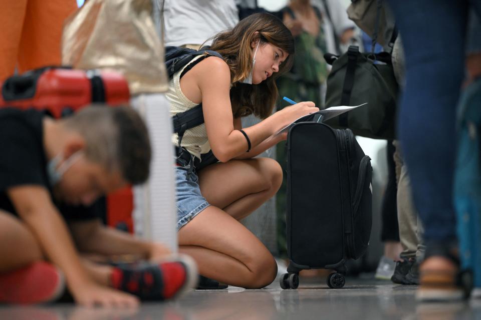Airlines: A passenger fills out a claim form at the Terminal 2 of El Prat airport in Barcelona. Photo: Lluis Gene/AFP via Getty