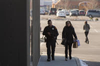 (Rick Egan | The Salt Lake Tribune) A police officer escorts a shopper to her car after a shooting at the Fashion Place Mall in Murray, Utah, on Sunday, Jan. 13, 2019. (Rick Egan/The Salt Lake Tribune via AP)