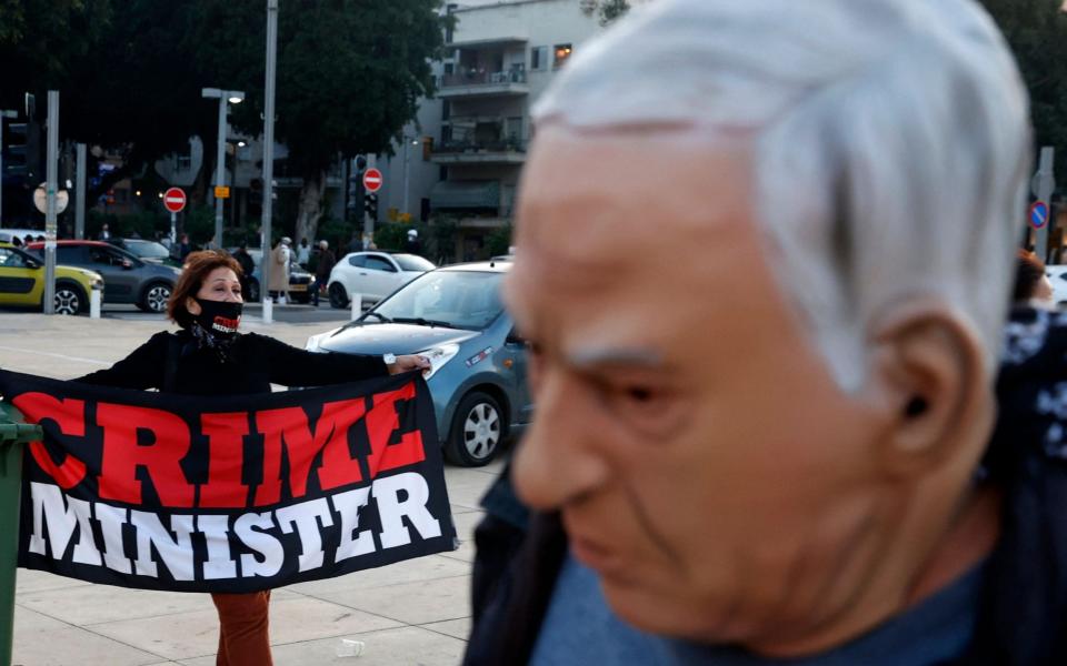 An Israeli disguised as Prime Minister Benjamin Netanyahu, walks past a fellow protester during a rally against the premier  - Jack Guez/AFP
