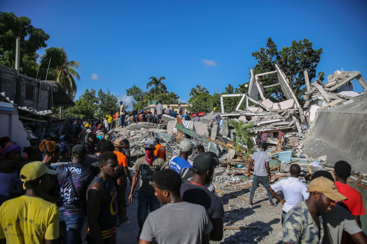 People search for survivors in a home destroyed by the earthquake in Les Cayes, Haiti, Saturday, Aug. 14, 2021.