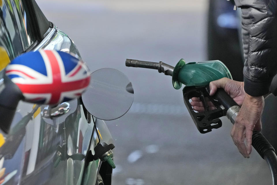 A driver fills a car with fuel at a petrol station in London