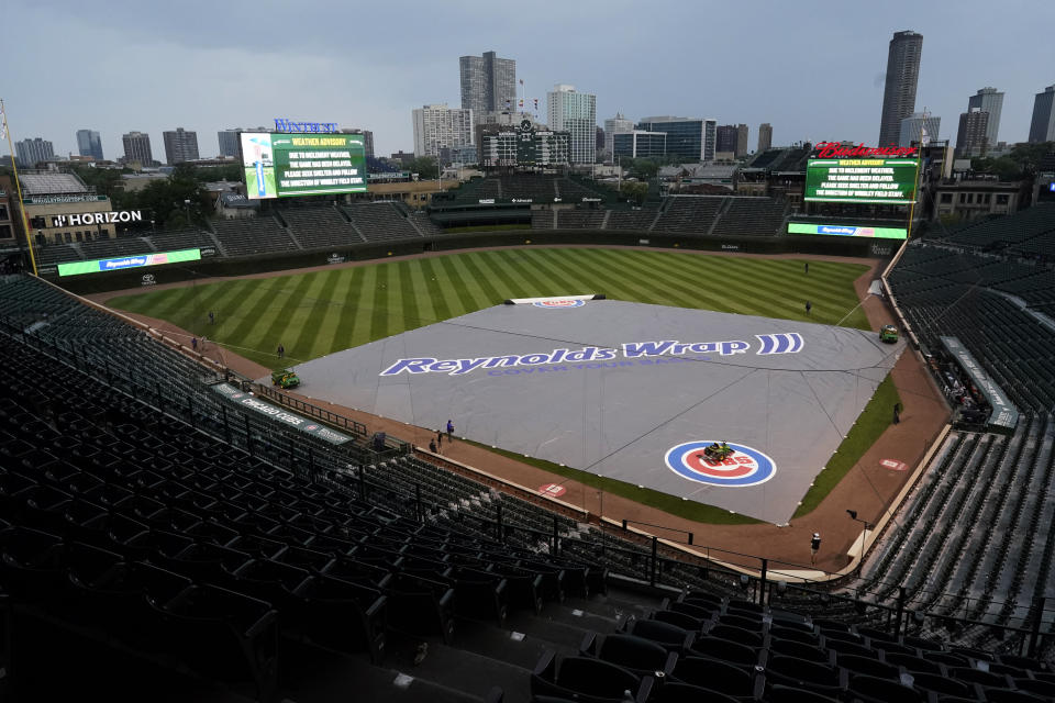 A tarp covers the infield during a rain delay in the ninth inning of a baseball game between the Arizona Diamondbacks and the Chicago Cubs in Chicago, Saturday, July 24, 2021. (AP Photo/Nam Y. Huh)