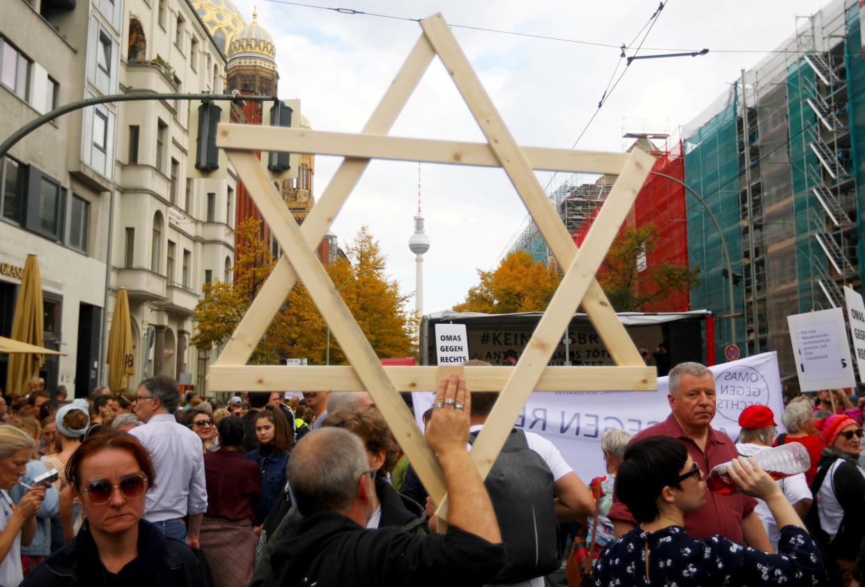 A man carries a wooden Star of David as people attend a demonstration themed with the slogan "#unteilbar" (indivisible) to protest against antisemitism, racism and nationalism in Berlin, Germany, October 13, 2019. REUTERS/Hannibal Hanschke