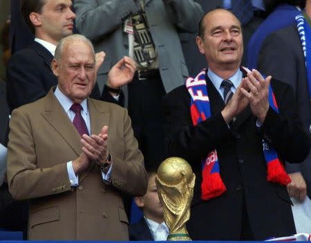 Joao Havalange (L) and French President Jacques Chirac applaud the teams as they walk onto the pitch for the World Cup final between France and Brazil at the Stade de France in Paris July 12, 1998. REUTERS/File photo