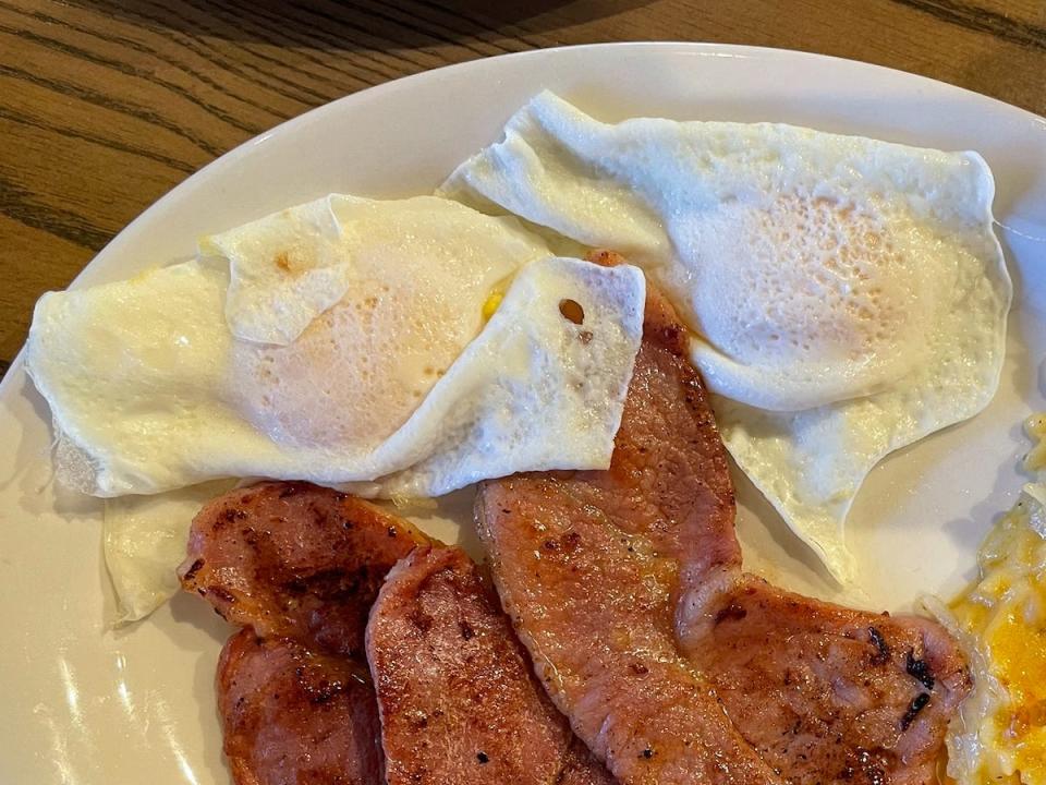 plate of ham, eggs, and hash brown casserole on a plate from cracker barrel