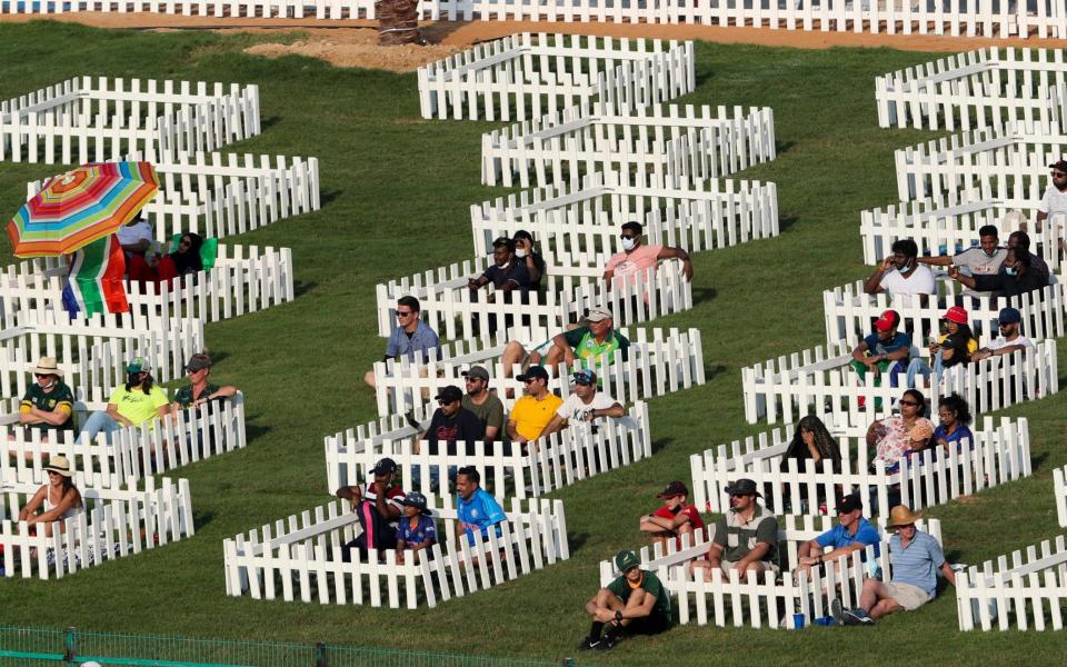 Spectators watch from fenced pens the Cricket Twenty20 World Cup match between South Africa and Australia in Abu Dhabi, UAE, Saturday, Oct. 23, 2021 - AP