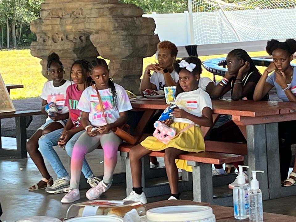 Students attending ASAHLA's Saturday Freedom School at Girls Inc. in Sarasota gather under the outdoor pavilion for lunch and announcements.