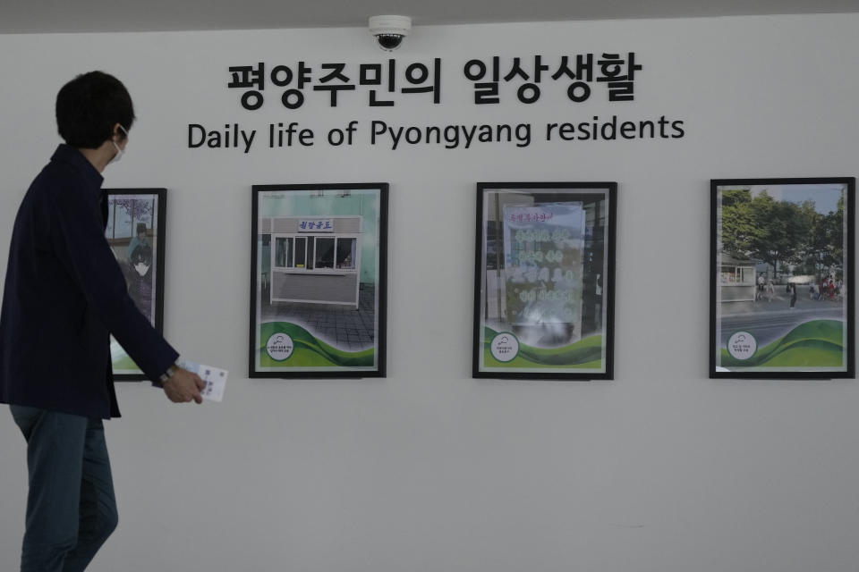 A visitor walks in front of pictures showing the North Korea's capitol Pyongyang at the unification observatory in Paju, South Korea, Wednesday, April 19, 2023. North Korean leader Kim Jong Un said his country has completed the development of its first military spy satellite and ordered officials to go ahead with its launch as planned, state media reported Wednesday. (AP Photo/Lee Jin-man)