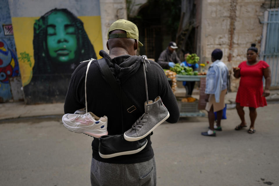 A street shoe vendor stands in Old Havana, Cuba, Wednesday, Jan. 31, 2024. (AP Photo/Ramon Espinosa)