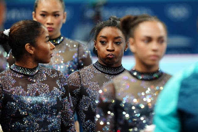 Puffing her cheeks out, Simone Biles alongside her US teammates. 