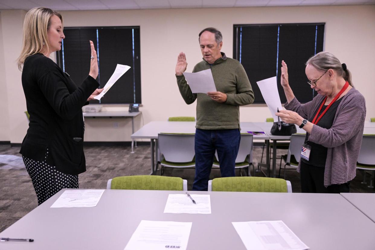 <span>Carly Koppes, left, administers the oath to election judges Tony Groeger, center, and Ann la Plante, right, in Greeley, Colorado, on 5 October 2022.</span><span>Photograph: Hyoung Chang/The Denver Post via Getty Images</span>