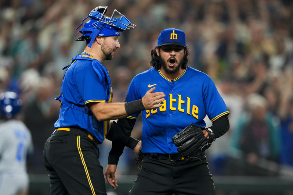 Seattle Mariners catcher Cal Raleigh, left, greets relief pitcher Andres Munoz after the team's win over the Kansas City Royals in a baseball game Friday, Aug. 25, 2023, in Seattle. (AP Photo/Lindsey Wasson)