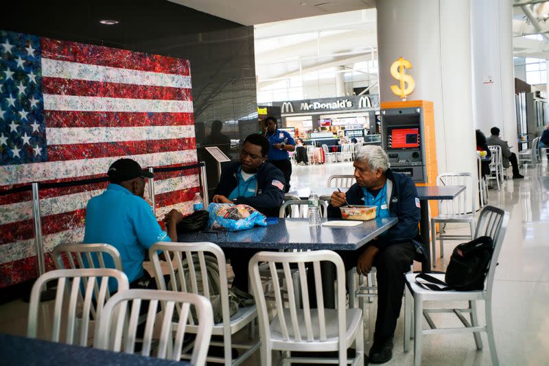 Airport workers eat in the food court after the Federal Aviation Administration (FAA) temporarily halted flights arriving at New York City airports due to coronavirus disease (COVID-19) in New York