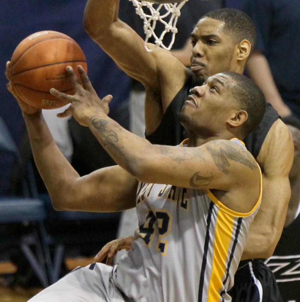 Kent State forward Darren Goodson (42) drives to the basket past Akron center Zeke Marshall at Rhodes Arena on Friday, Mar. 8.