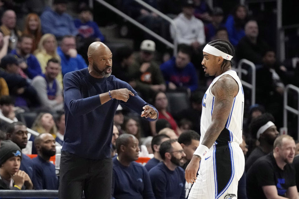 Orlando Magic head coach Jamahl Mosley talks to guard Gary Harris during the first half of an NBA basketball game against the Detroit Pistons, Saturday, Feb. 24, 2024, in Detroit. (AP Photo/Carlos Osorio)