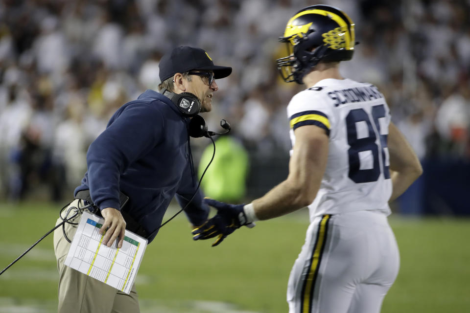 Michigan head coach Jim Harbaugh, left, greets tight end Luke Schoonmaker (86) as he returns to the sidelines during the first half of an NCAA college football game against Penn State in State College, Pa., Saturday, Oct. 19, 2019. (AP Photo/Gene J. Puskar)