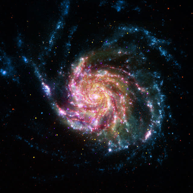 This image of Messier 101, also known as the Pinwheel Galaxy, combines data in the infrared, visible, ultraviolet and X-rays from Spitzer and three other NASA space telescopes. | NASA/JPL-Caltech/STScI/CXC