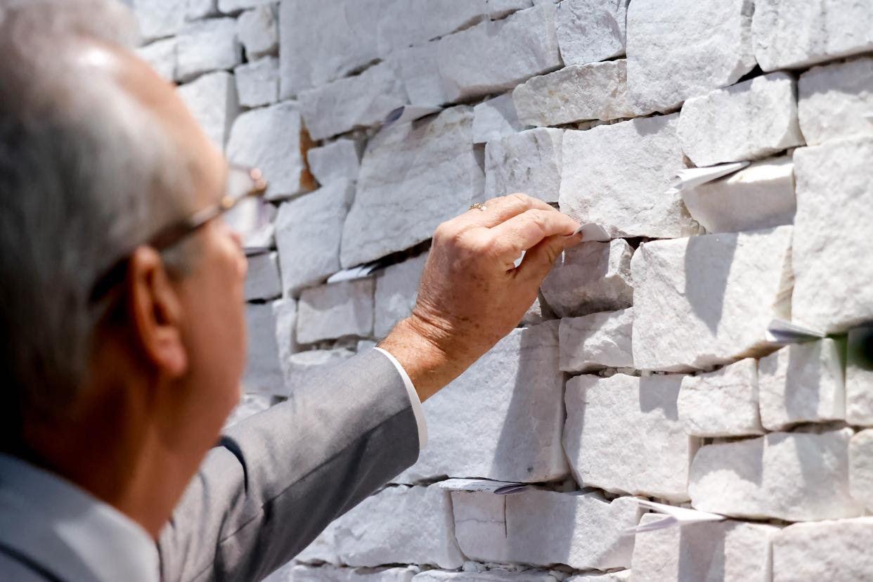 A person attending the recent Earlywine Park YMCA Prayer Wall Dedication Ceremony places his written prayer in the crevice of the prayer wall at the south Oklahoma City Y.