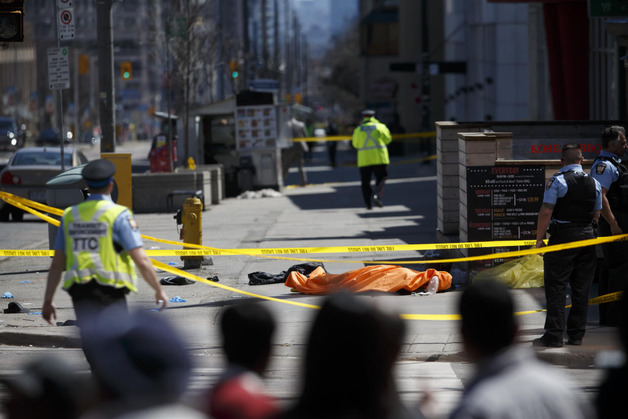 A tarp lays on top of a body on Yonge St. at Finch Ave. after a van plowed into pedestrians on April 23, 2018 in Toronto, Canada. A suspect is in custody after a white van collided with multiple pedestrians. (Photo by Cole Burston/Getty Images)