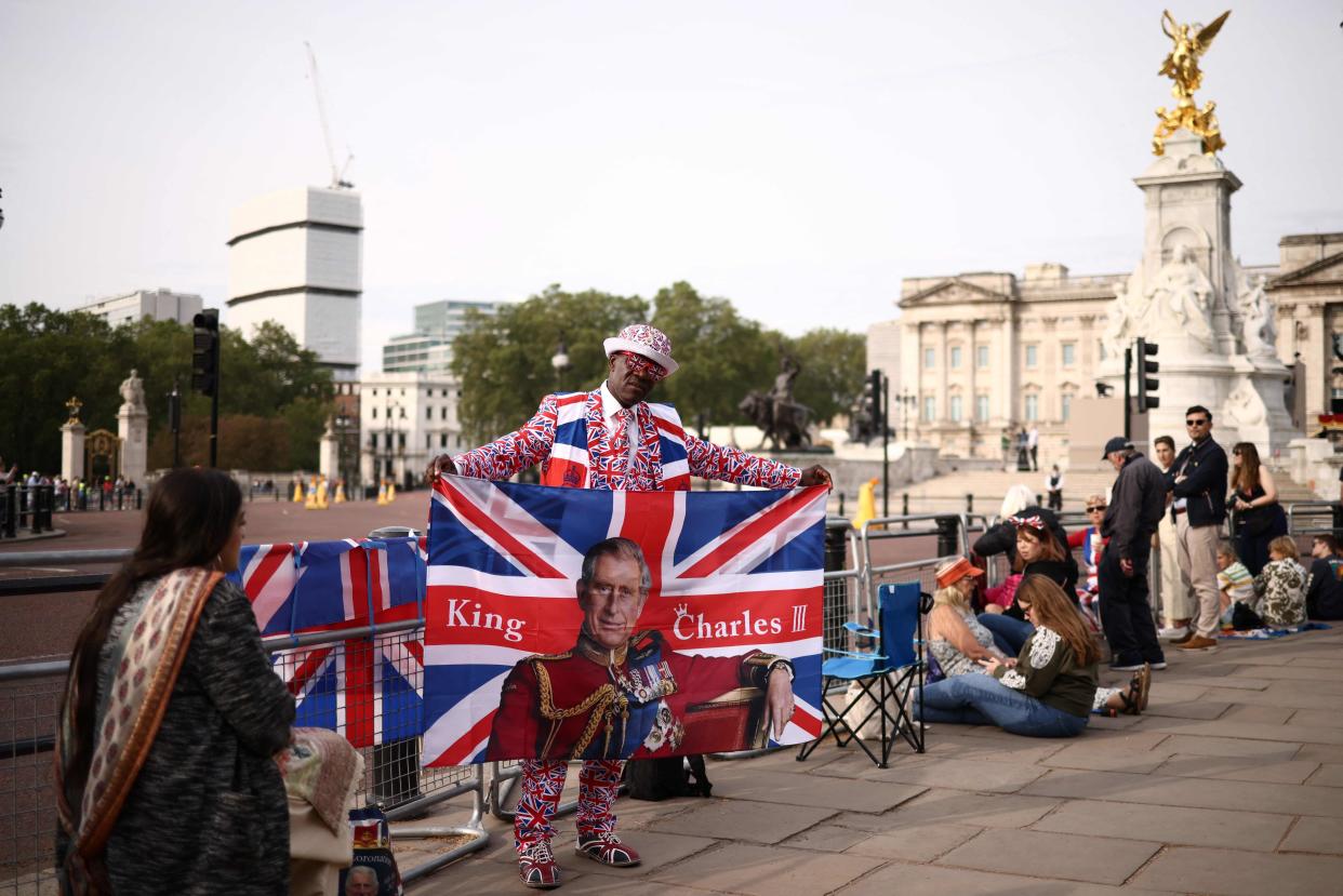 Royal super fan poses at the Queen Victoria Memorial in front of Buckingham Palace prior to the King's Birthday Parade (AFP via Getty Images)