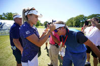 Lexi Thompson, front left, signs the visor of Bobby Varwig of Bedford, Ohio, after finishing her round during the first round of the Dana Classic LPGA golf tournament Thursday, Sept. 1, 2022, at the Highland Meadows Golf Club in Sylvania, Ohio. (AP Photo/Gene J. Puskar)