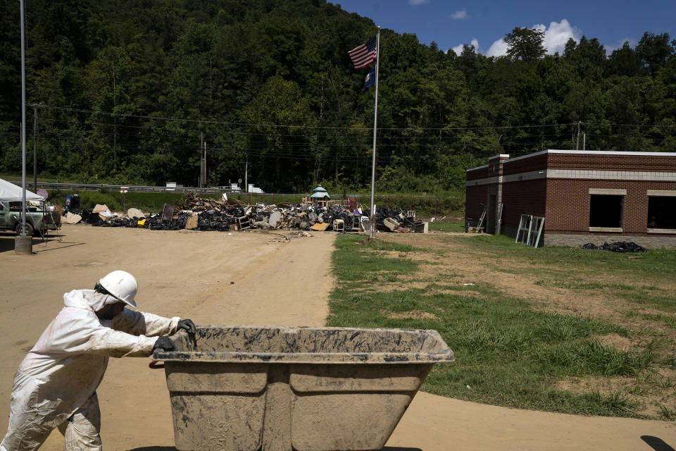 Image: Employees of Servpro, a restoration company, carry debris and contents of classrooms out of the Buckhorn School on Aug. 19, 2022, in Buckhorn, Ky. (Michael Swensen for NBC News)