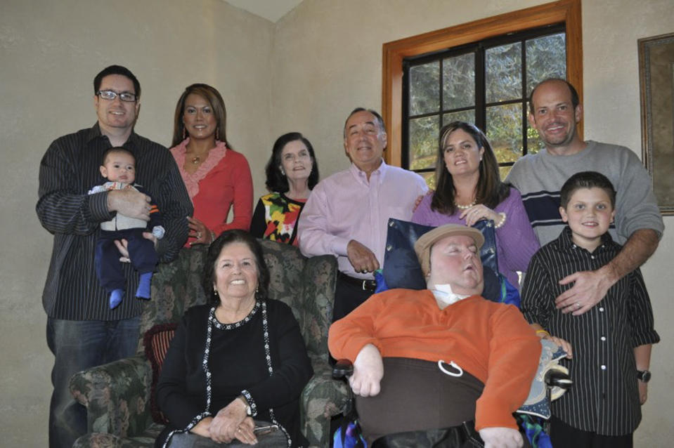 This Nov. 25, 2010 photo provided by Paul Cortez shows Mikey Cortez, front row, center, and his family members on Thanksgiving Day. As his 7-year-old son Mikey lay in a hospital bed on life support, the victim of a drunk driver who had smashed into the car he was riding in, Paul Cortez took the boy's hand and made a solemn promise to God: If his son survived, no matter in what condition, he and his family would always be there for him. Although he would never emerge from the persistent vegetative state his father had found him in that night, Mikey’s family was not only there for him but also gave him a full life. A life, as it turned out, not all that different from anybody else’s, with cross-country family vacations and visits to Disneyland. (AP Photo/Courtesy Cortez Family)