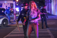 Police escort a man out of the area after an officer was shot, Wednesday, Sept. 23, 2020, in Louisville, Ky. A grand jury has indicted one officer on criminal charges six months after Breonna Taylor was fatally shot by police in Kentucky. The jury presented its decision against fired officer Brett Hankison Wednesday to a judge in Louisville, where the shooting took place. (AP Photo/John Minchillo)