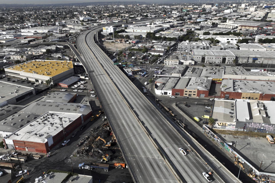 In this aerial view, Interstate 10 is empty due to a closure in the aftermath of a fire, Monday, Nov. 13, 2023, in Los Angeles. Los Angeles drivers are being tested in their first commute since a weekend fire that closed a major elevated interstate near downtown. (AP Photo/Jae C. Hong)