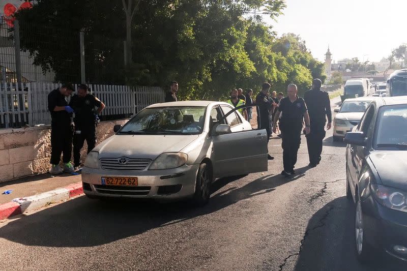 Israeli police work next to the car at the scene of a shooting incident in East Jerusalem